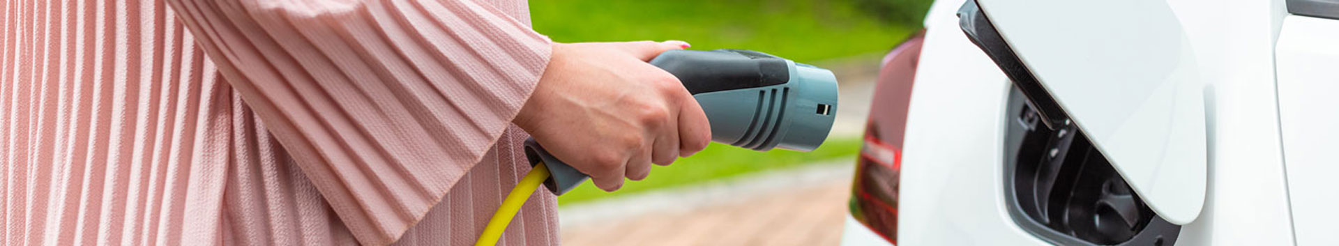 Photo of person plugging in a car for charging