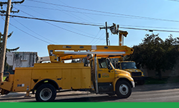 Image showing utility truck fixing power pole along a busy street