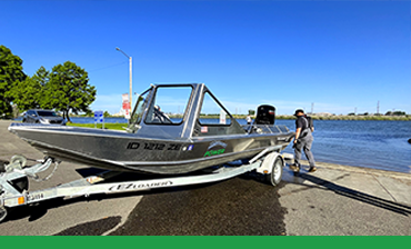 Silver aluminum jet boat next to a dock