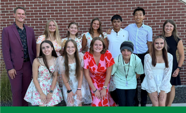 Group of smiling people in front of brick wall